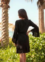 The Sharon in black is a flattering wrap dress with fluted sleeves. Part of the CAHA CAPO women's resortwear collection.