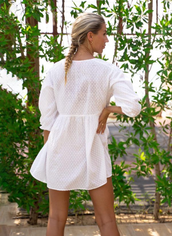 The Ivy is a white summer dress made in textured cotton with crochet trim. Part of the CAHA CAPO women's resortwear collection.